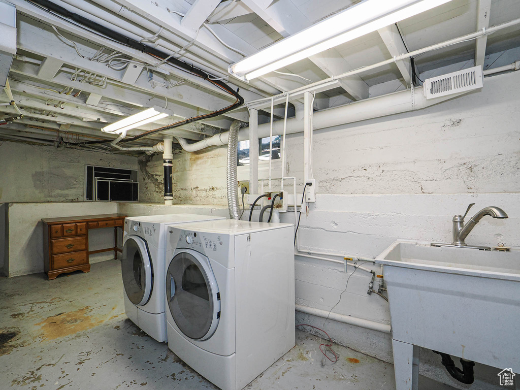 Laundry area with a sink, separate washer and dryer, laundry area, and visible vents