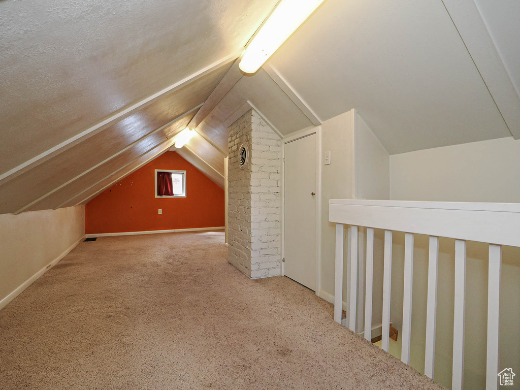 Bonus room featuring carpet floors, baseboards, and lofted ceiling
