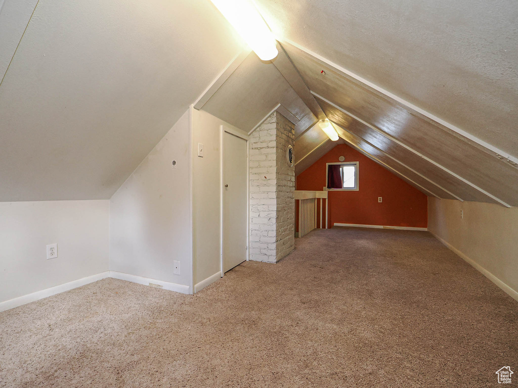 Bonus room with carpet floors, baseboards, and vaulted ceiling