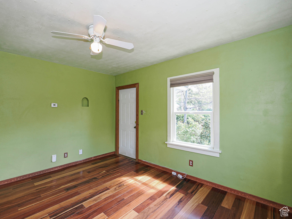 Unfurnished room featuring baseboards, ceiling fan, and wood finished floors