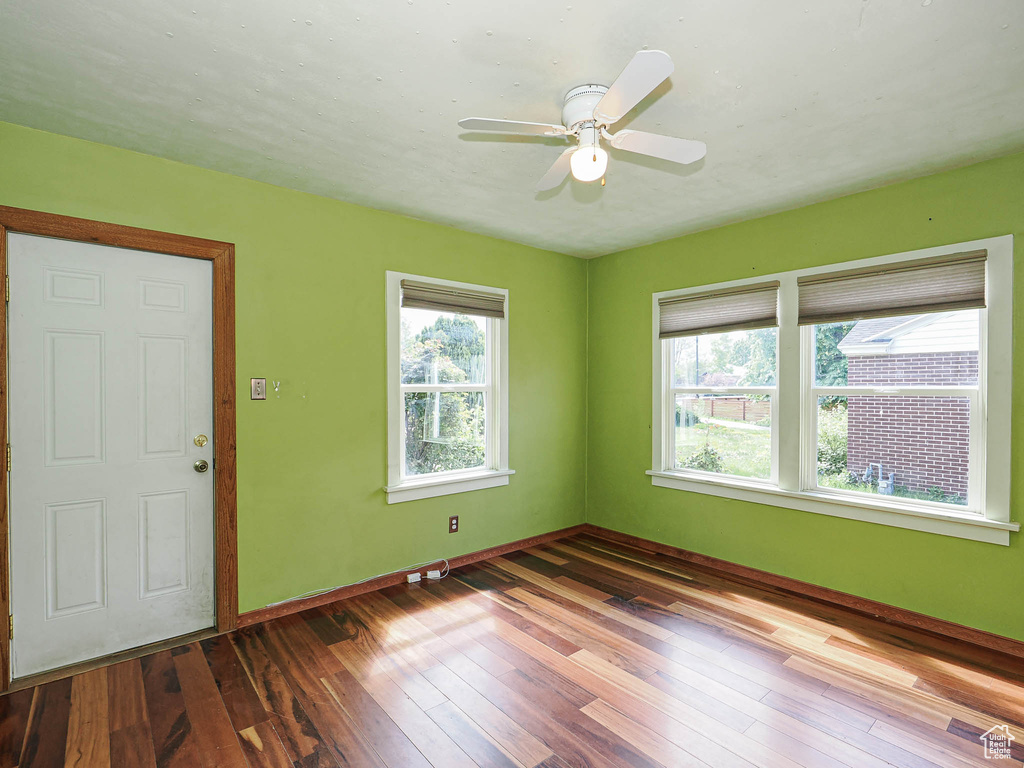 Spare room with wood-type flooring, ceiling fan, and baseboards