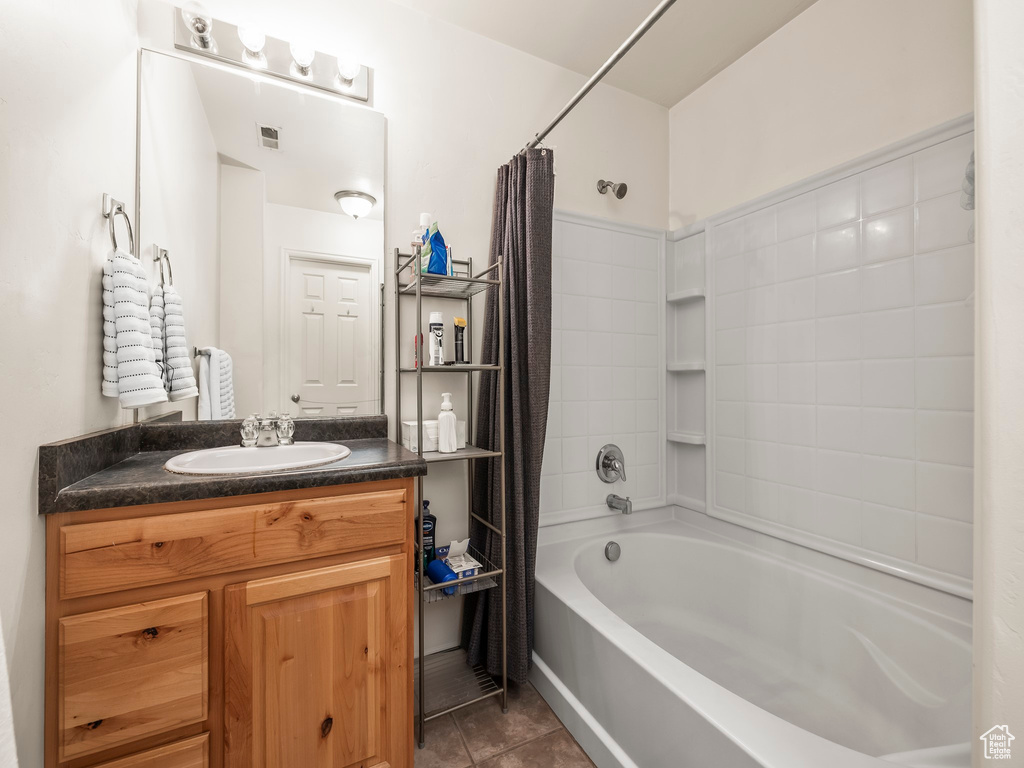 Full bath featuring tile patterned floors, vanity, and shower / bath combination with curtain