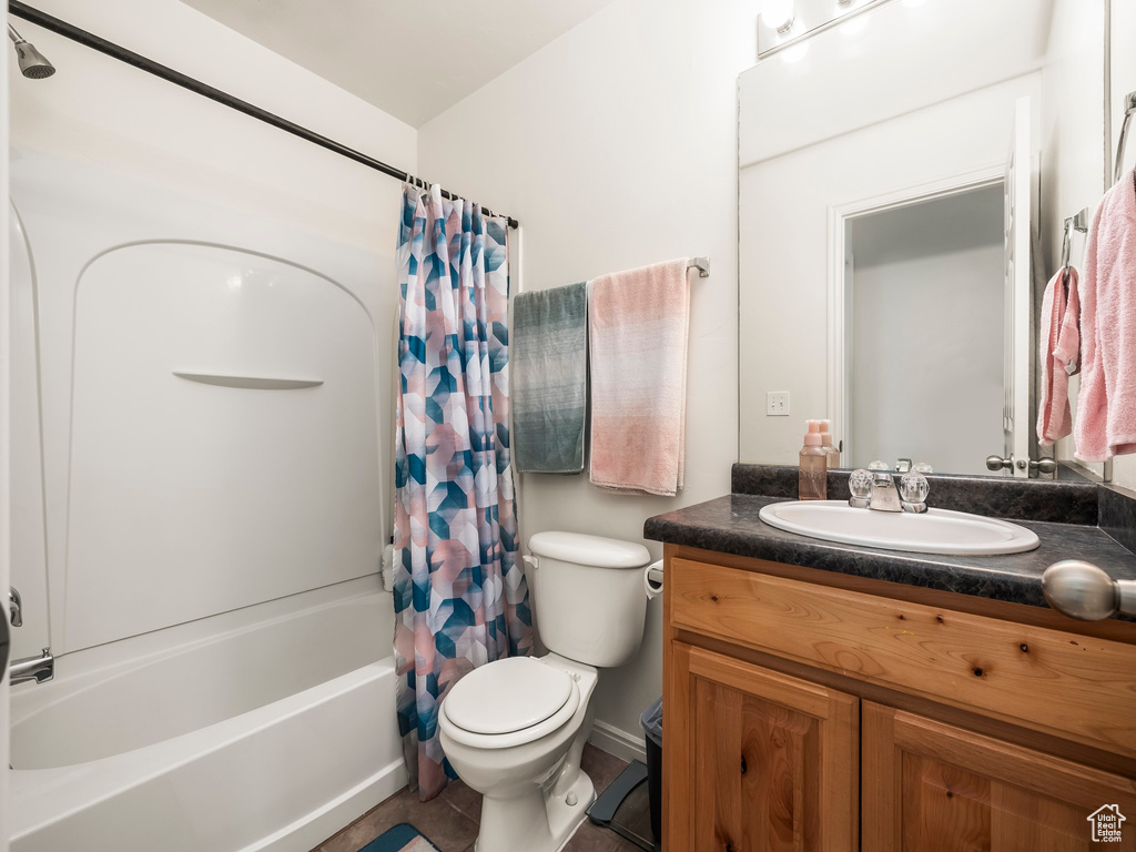 Full bathroom with toilet, shower / bath combo, and vanity