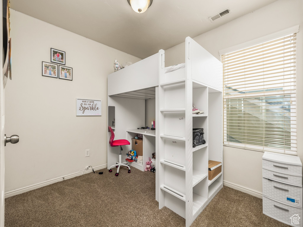 Carpeted bedroom with visible vents and baseboards