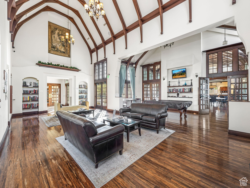 Living room featuring wood-type flooring, high vaulted ceiling, and a chandelier