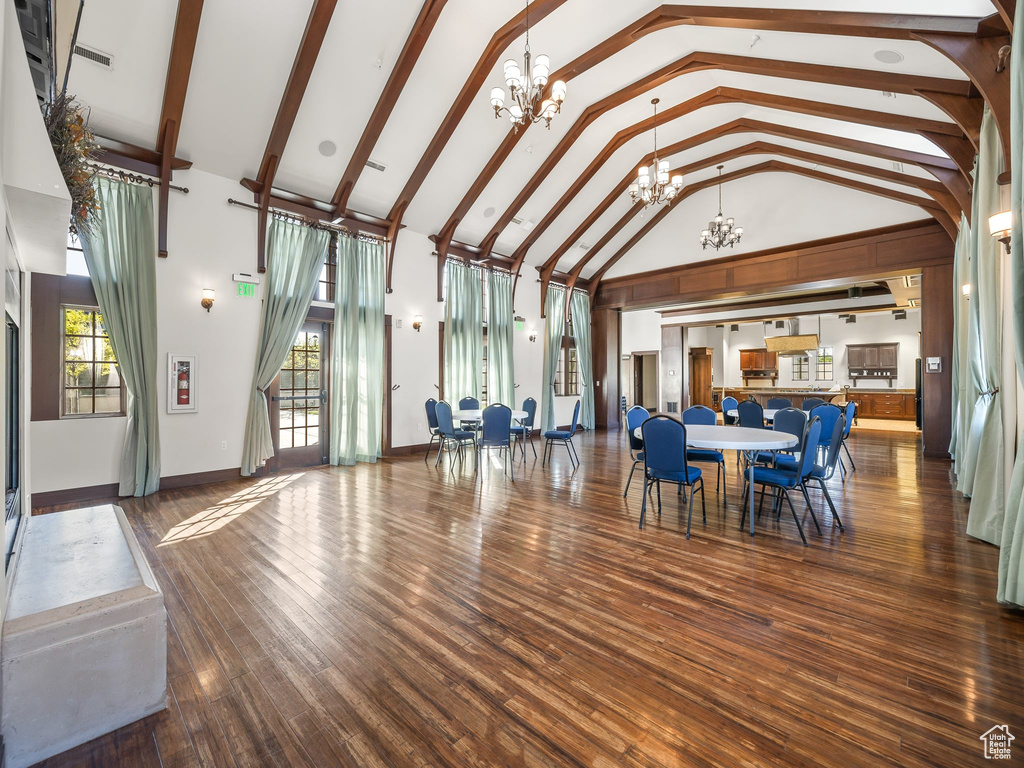 Interior space with an inviting chandelier, high vaulted ceiling, and hardwood / wood-style flooring