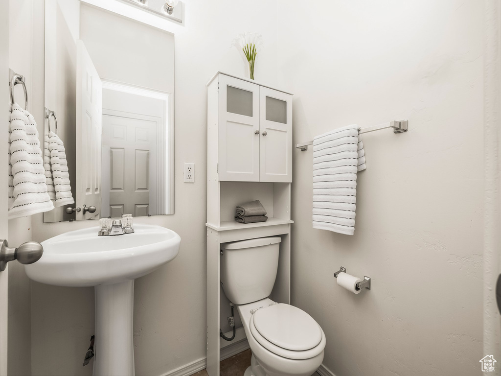 Half bath featuring toilet and baseboards