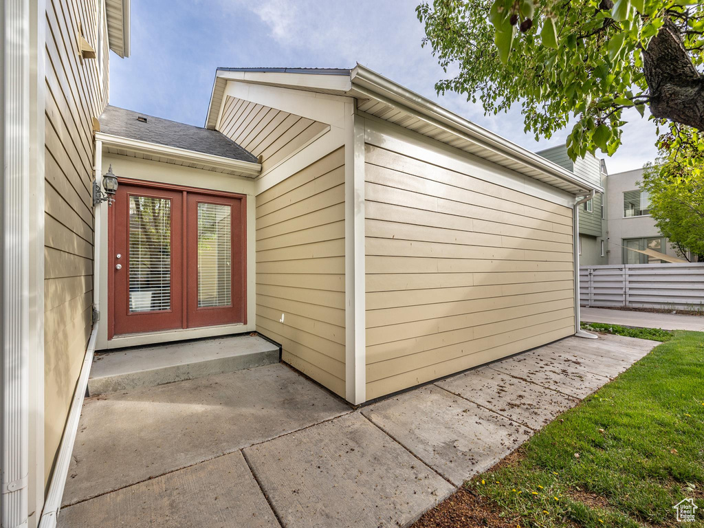 Entrance to property featuring a patio area, fence, and french doors
