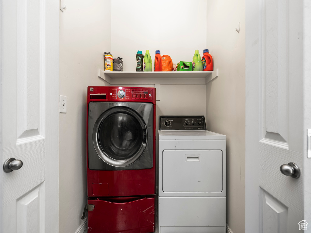 Washroom with baseboards, laundry area, and washing machine and dryer