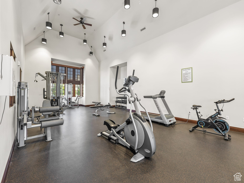 Workout area with high vaulted ceiling, ceiling fan, and baseboards