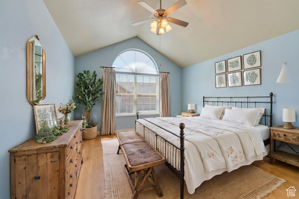 Bedroom with a ceiling fan, lofted ceiling, and light wood finished floors