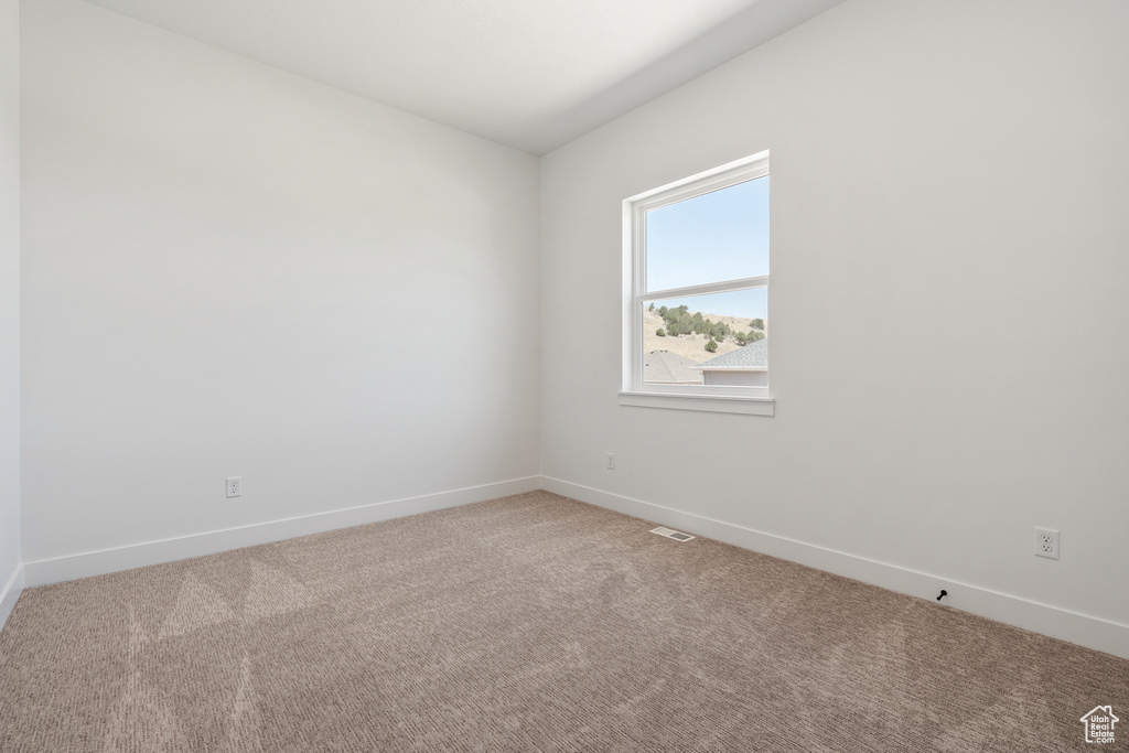 Spare room with baseboards, carpet flooring, and visible vents