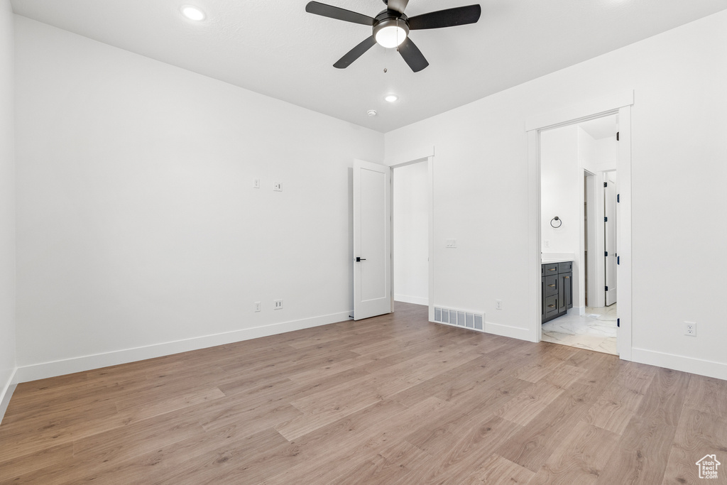 Unfurnished bedroom with visible vents, light wood-style floors, baseboards, recessed lighting, and connected bathroom
