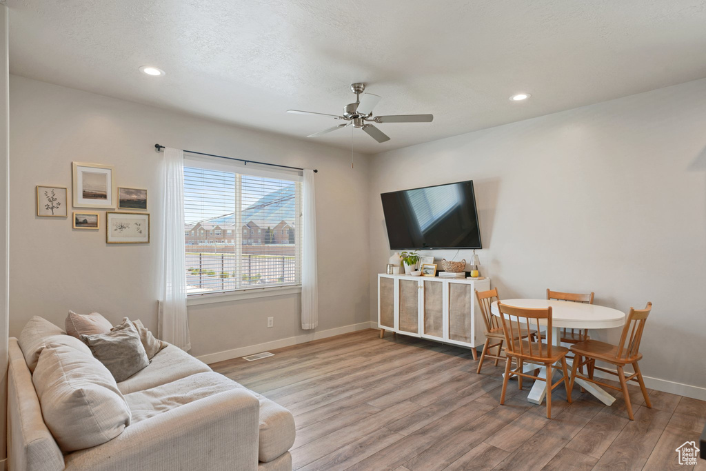 Living room with baseboards, ceiling fan, recessed lighting, and wood finished floors
