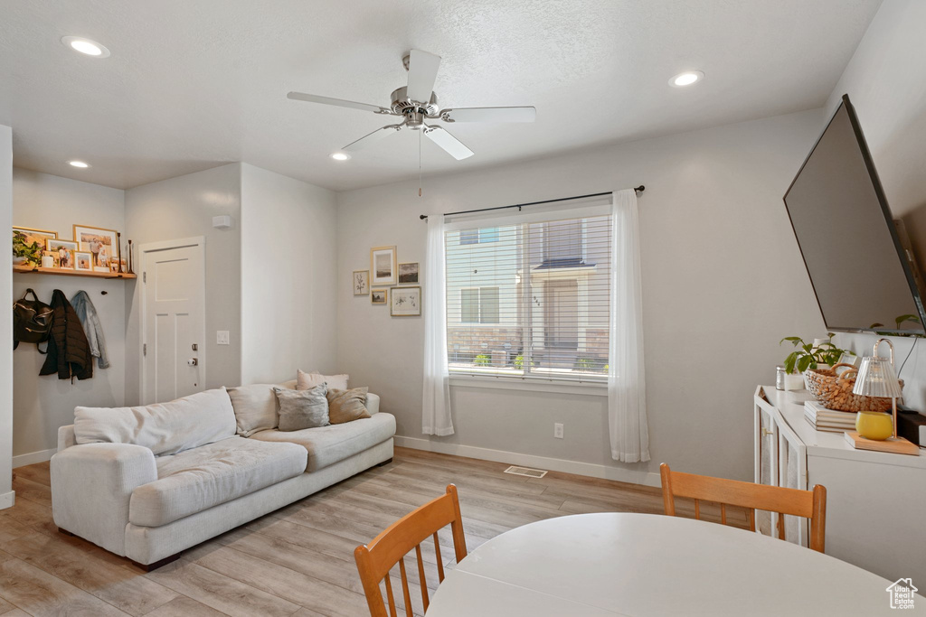 Living area featuring light wood-style floors, baseboards, a ceiling fan, and recessed lighting