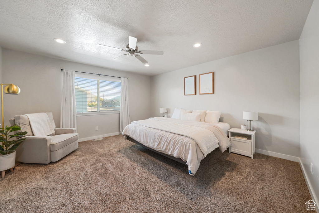 Carpeted bedroom featuring a textured ceiling, baseboards, recessed lighting, and a ceiling fan