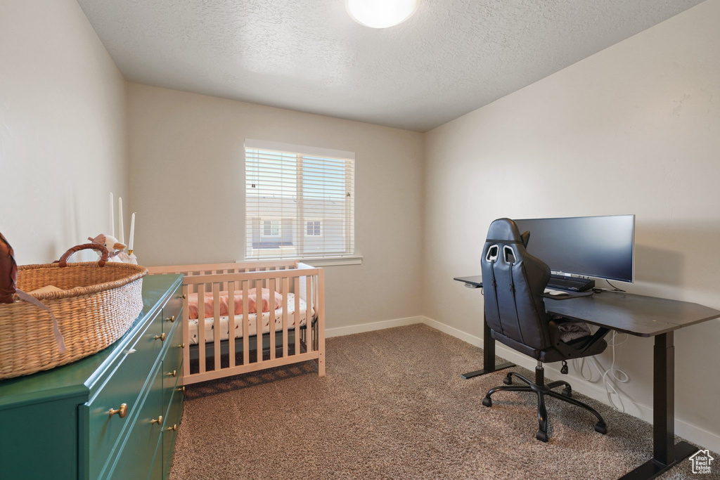 Bedroom with baseboards, carpet flooring, and a textured ceiling