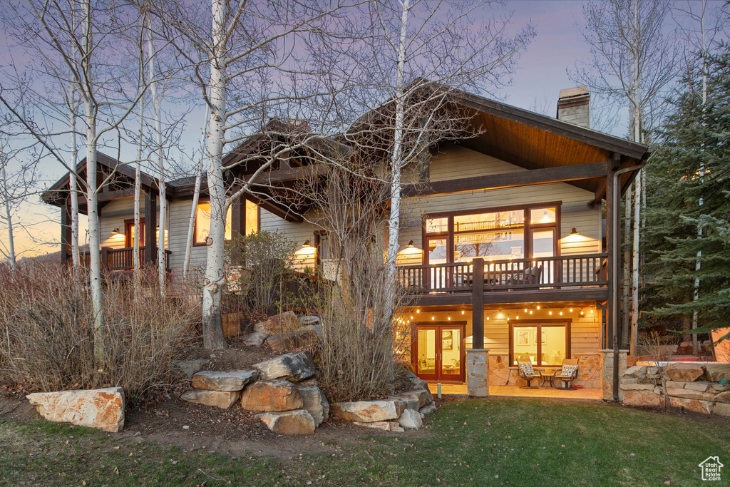 Back of house with a patio, a yard, and a chimney