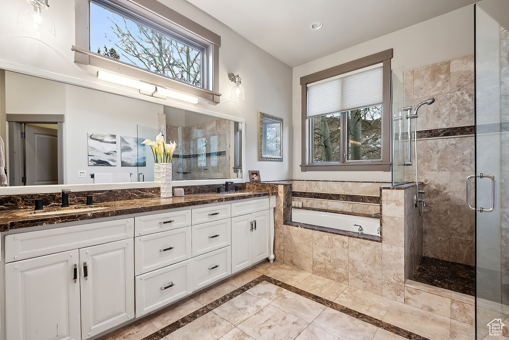 Bathroom featuring plenty of natural light, a sink, double vanity, and a shower stall