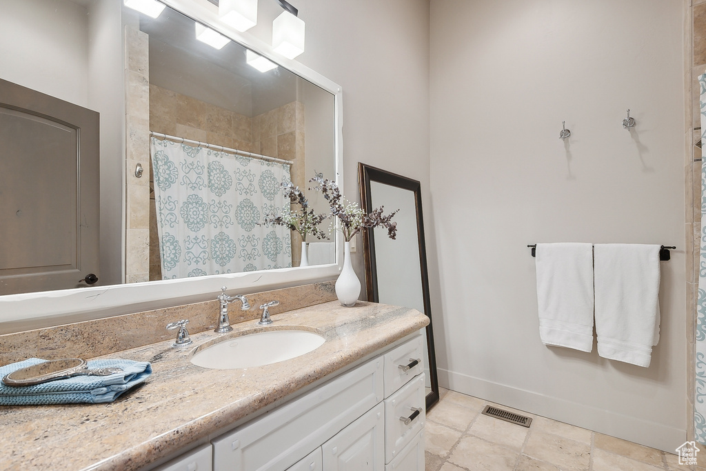 Full bathroom featuring baseboards, visible vents, curtained shower, and vanity