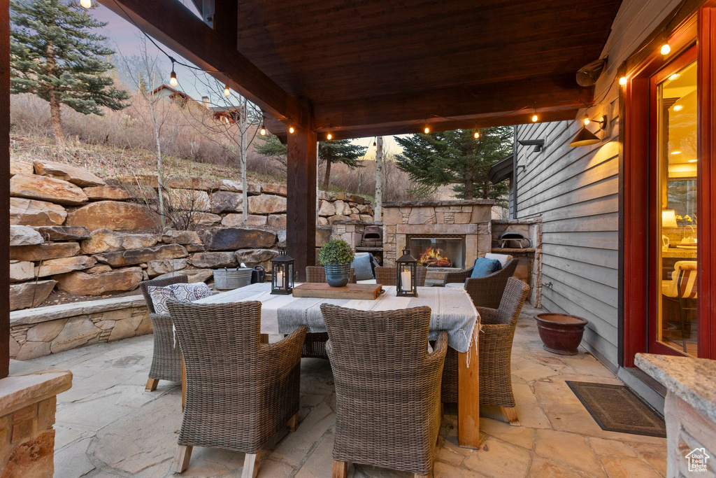 View of patio / terrace featuring an outdoor stone fireplace and outdoor dining space
