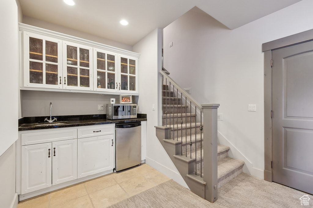 Bar featuring indoor wet bar, a sink, stairs, and stainless steel appliances