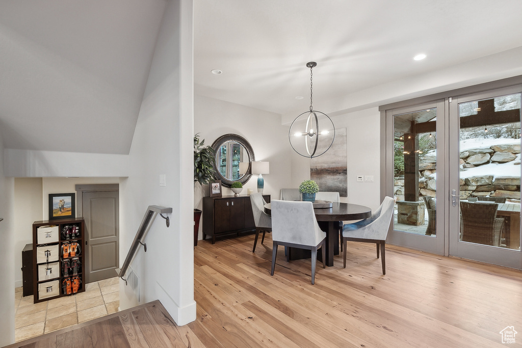 Dining area with light wood-style floors, plenty of natural light, recessed lighting, and a notable chandelier