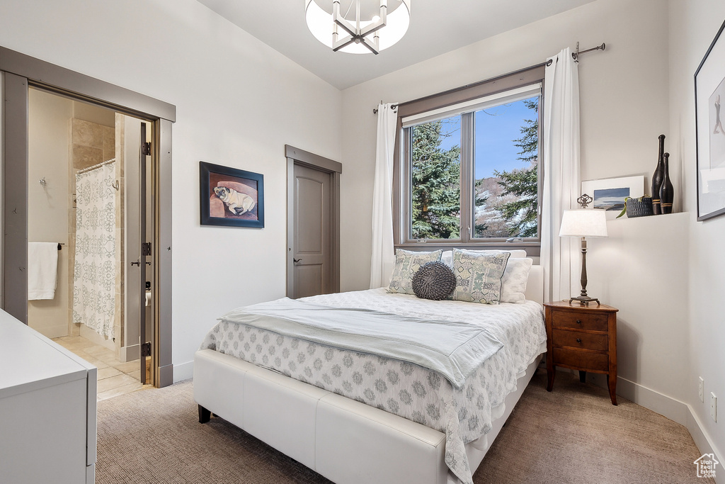 Bedroom featuring baseboards, an inviting chandelier, and light carpet