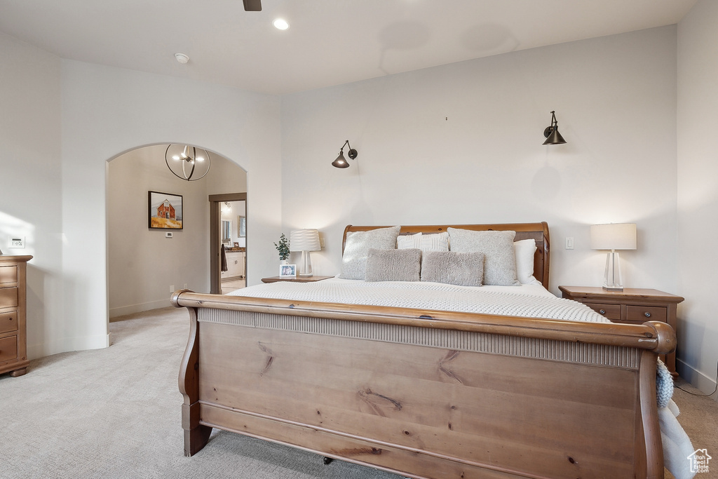 Bedroom featuring light colored carpet, arched walkways, and baseboards