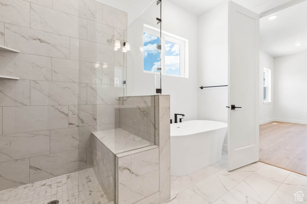 Bathroom with marble finish floor, recessed lighting, baseboards, a freestanding tub, and tiled shower