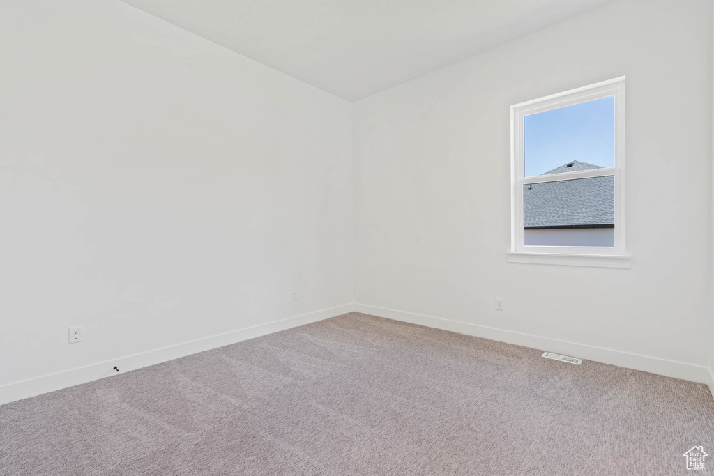 Empty room featuring baseboards, carpet flooring, and visible vents