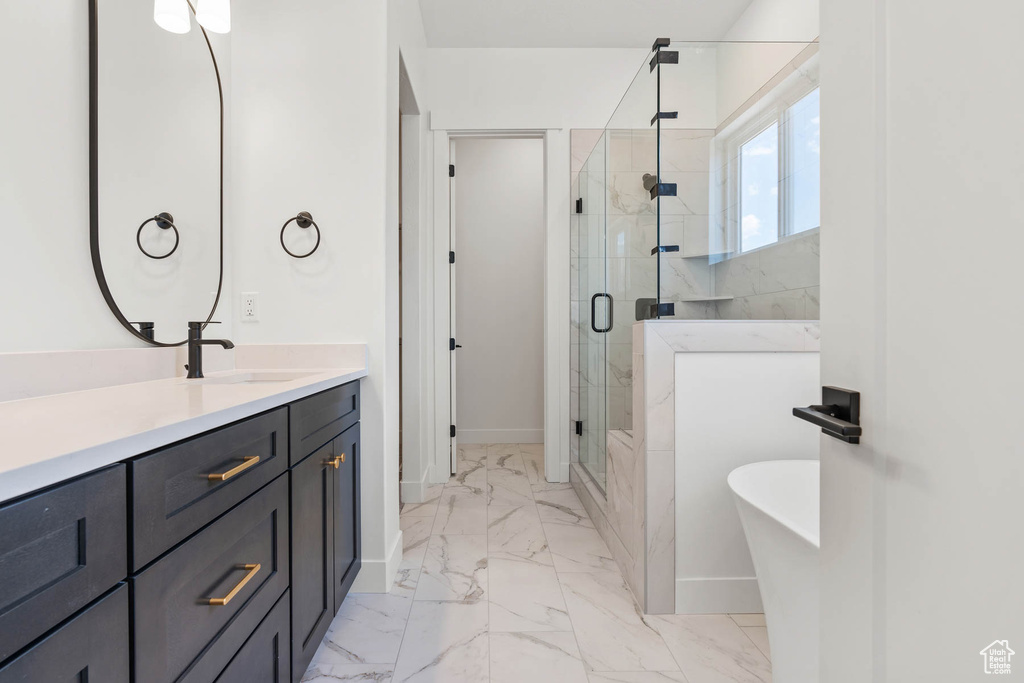 Full bath with a freestanding tub, baseboards, a stall shower, and marble finish floor