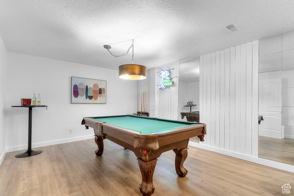 Rec room with light wood-style floors, a textured ceiling, baseboards, and pool table