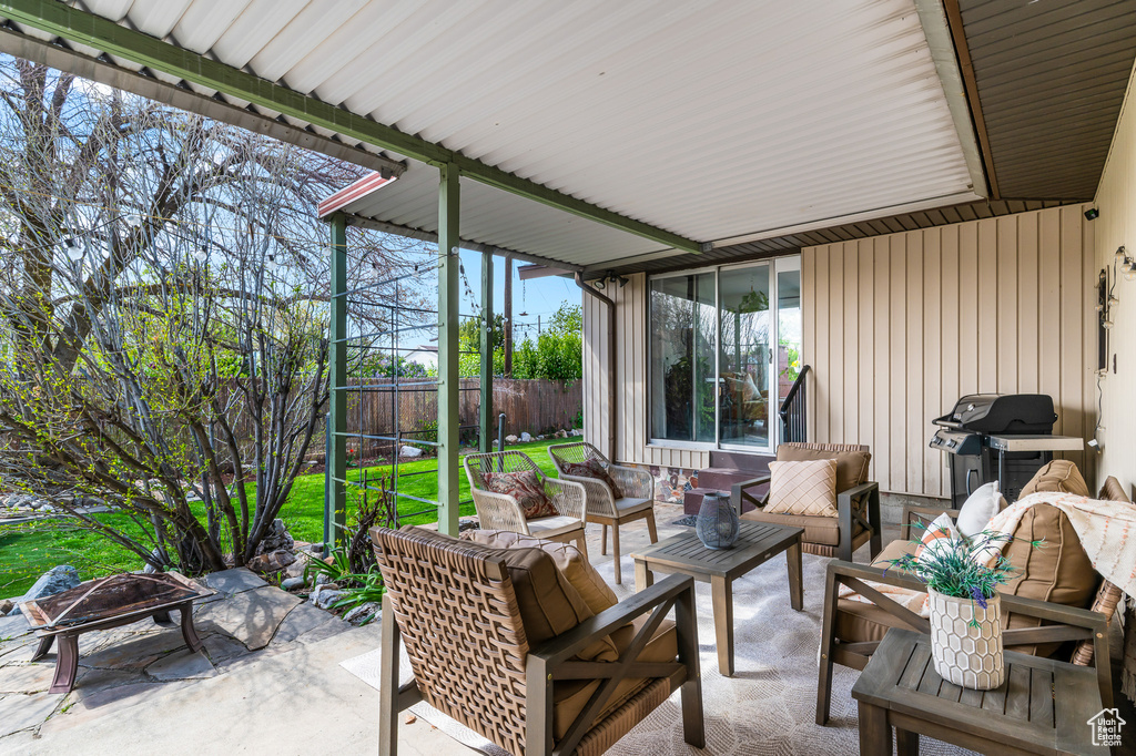 View of patio / terrace with an outdoor living space with a fire pit, fence, and a grill