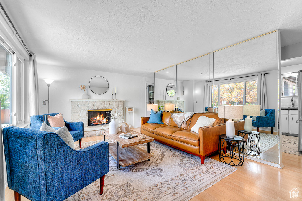 Living area featuring a textured ceiling, wood finished floors, and a fireplace
