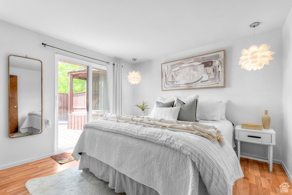 Bedroom with access to outside, baseboards, and light wood-style flooring