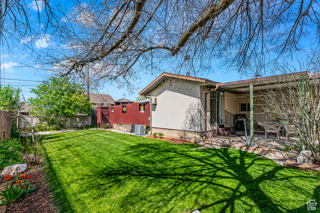 Exterior space featuring central AC, a fenced backyard, entry steps, and a patio area