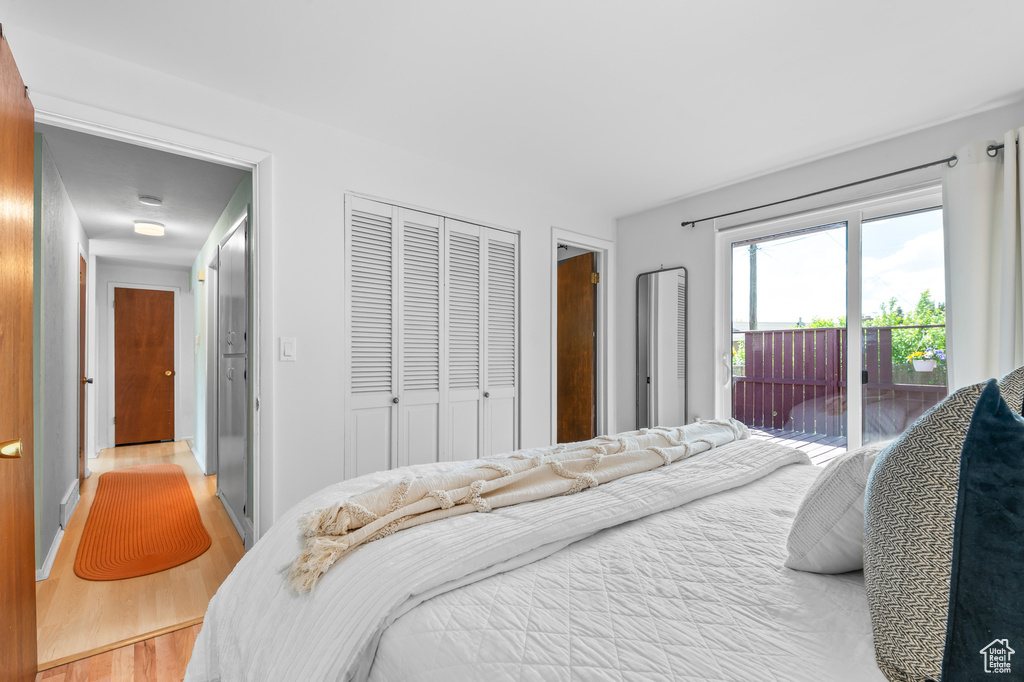 Bedroom with access to outside, light wood-style flooring, and a closet