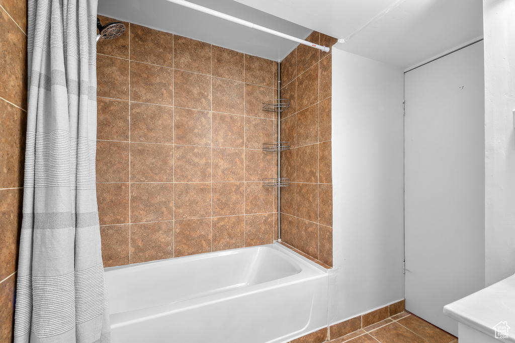 Full bath with tile patterned floors, baseboards, and shower / tub combo