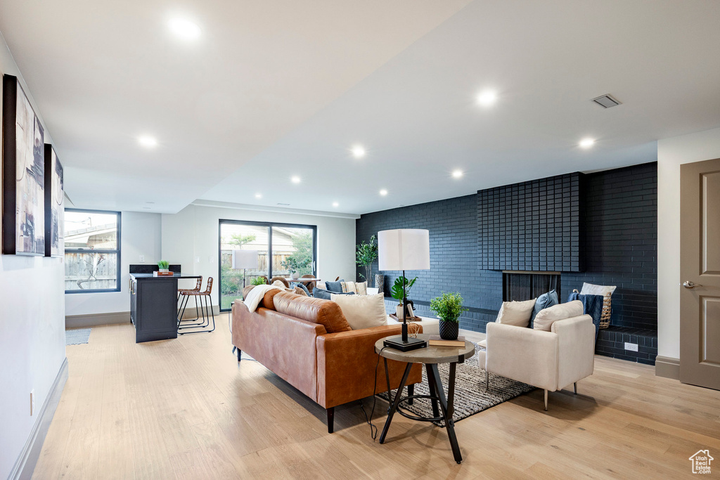 Living room with light wood-style floors, baseboards, recessed lighting, and a tile fireplace