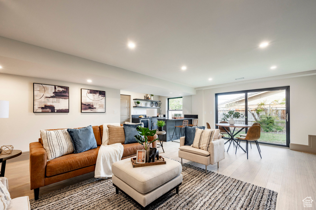 Living area featuring light wood-style floors, baseboards, and recessed lighting