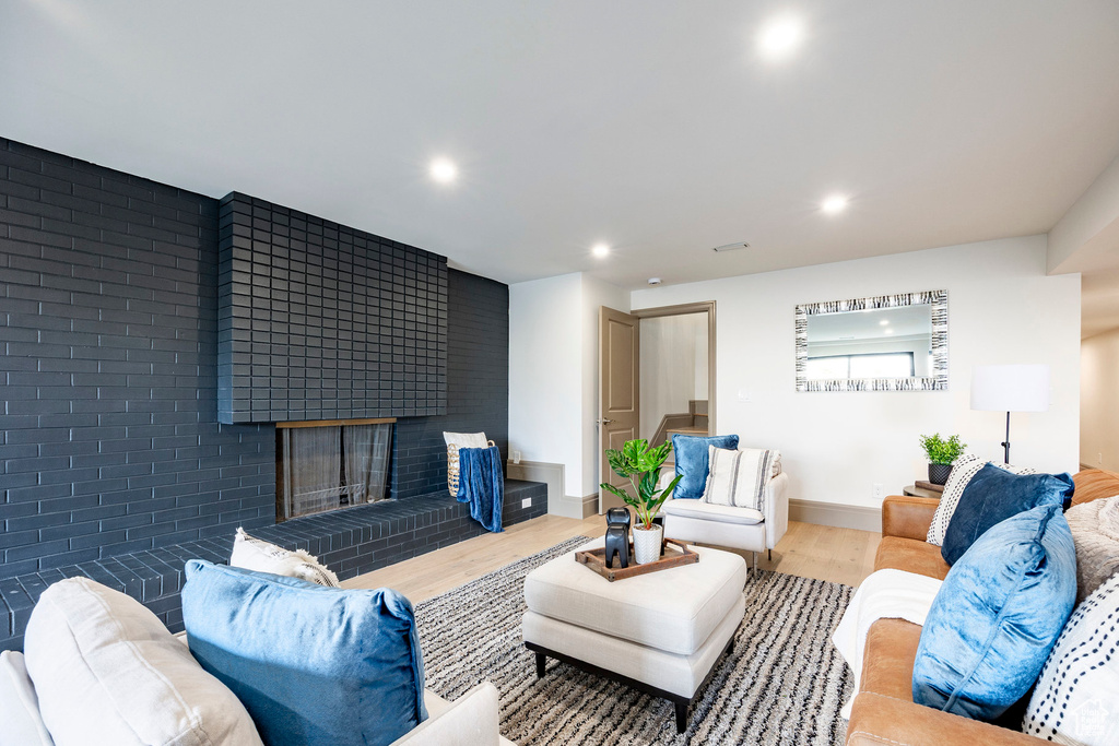 Living area featuring recessed lighting, a brick fireplace, and wood finished floors