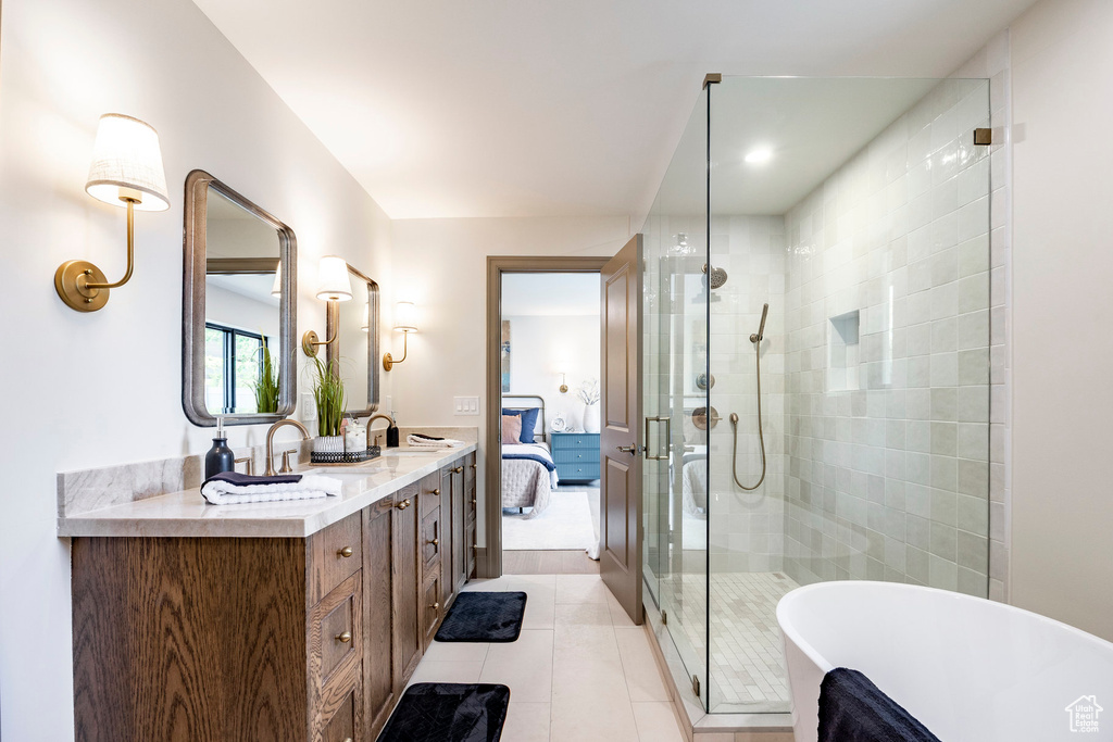Full bathroom with a freestanding bath, tile patterned flooring, ensuite bath, double vanity, and a stall shower