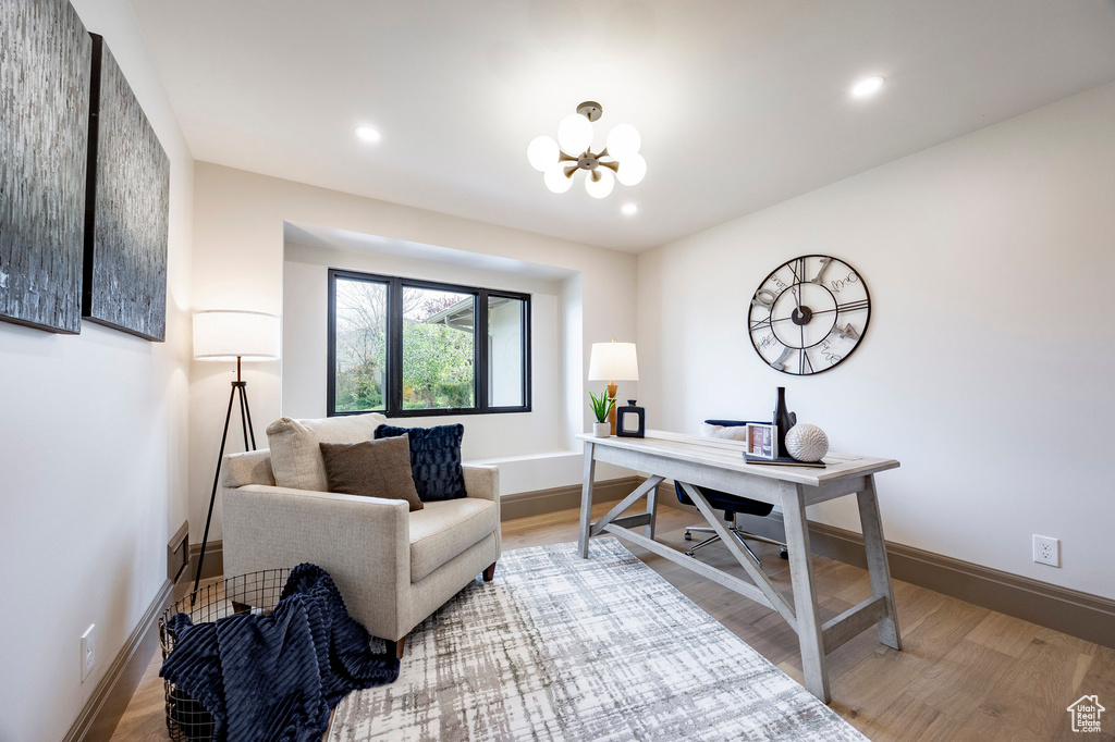 Office area featuring baseboards, recessed lighting, wood finished floors, and a notable chandelier