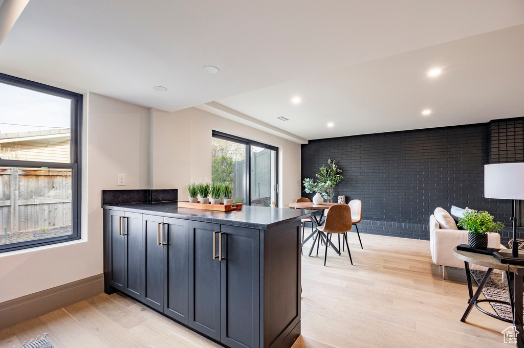 Kitchen with a peninsula, dark countertops, baseboards, recessed lighting, and light wood finished floors
