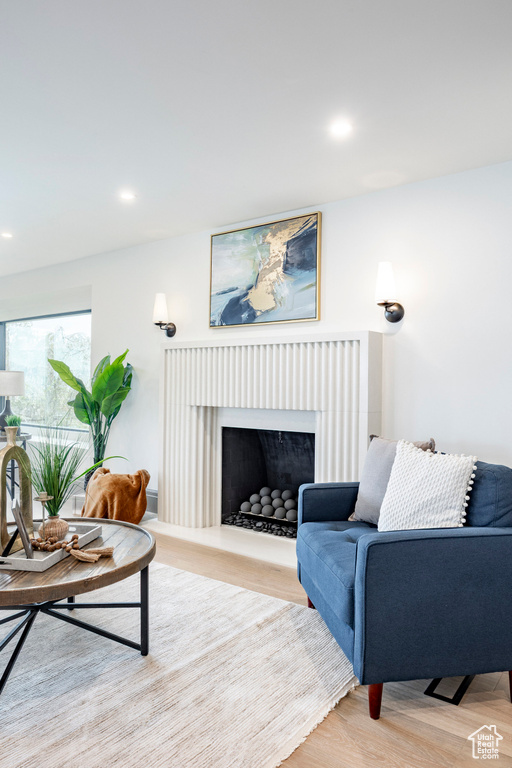 Living room with recessed lighting, wood finished floors, and a fireplace