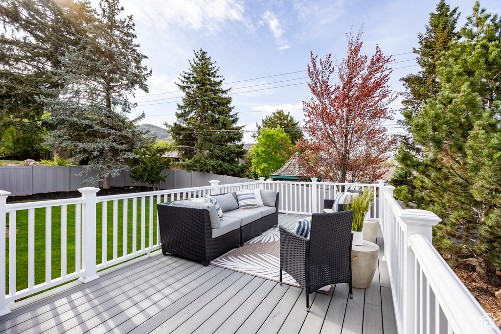 Wooden deck with a lawn, an outdoor living space, and a fenced backyard