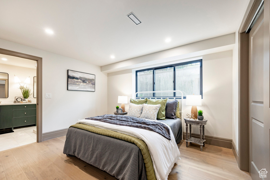 Bedroom with connected bathroom, recessed lighting, baseboards, and light wood-type flooring