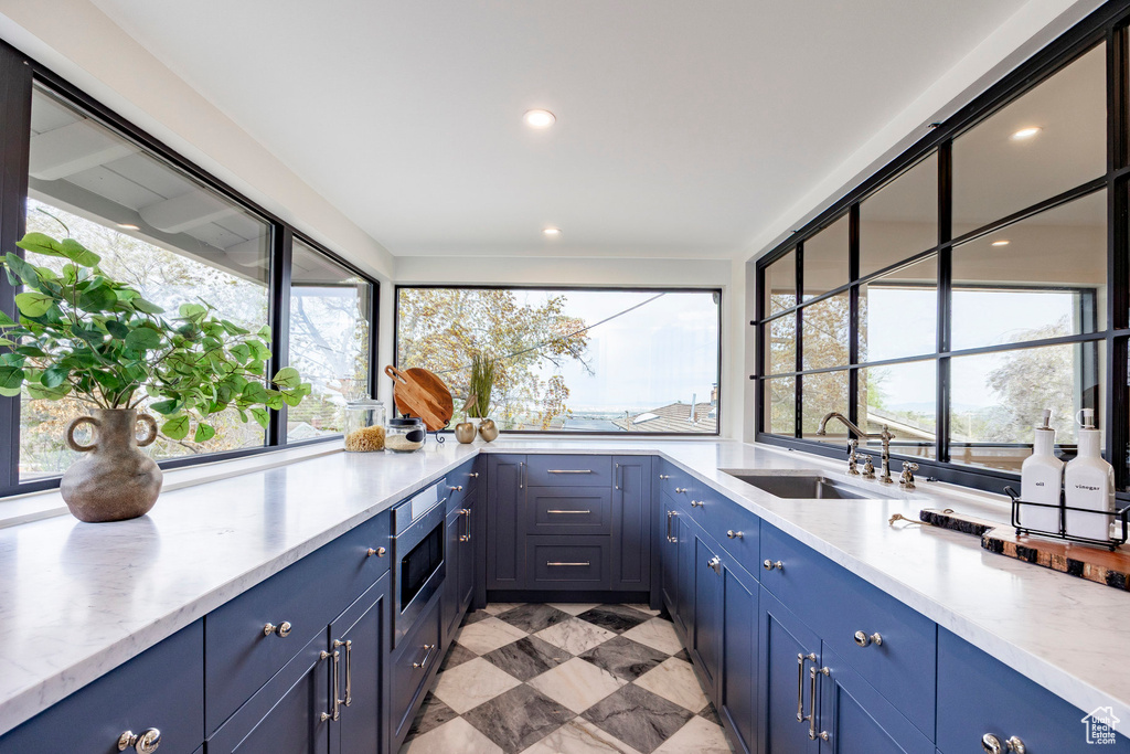 Kitchen with plenty of natural light, a sink, and blue cabinetry
