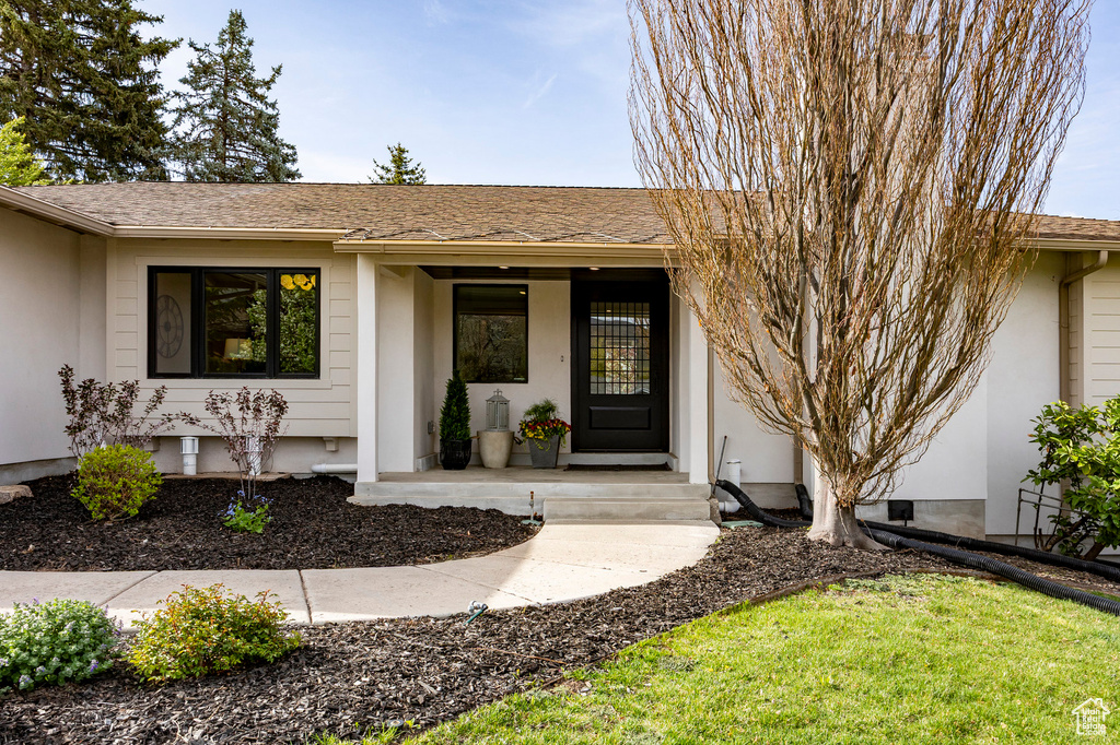 Entrance to property featuring a porch and stucco siding
